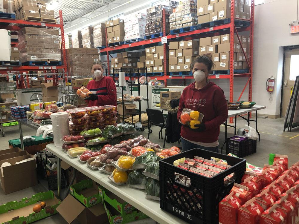An image of two Mississauga Food Bank volunteers packing fresh food