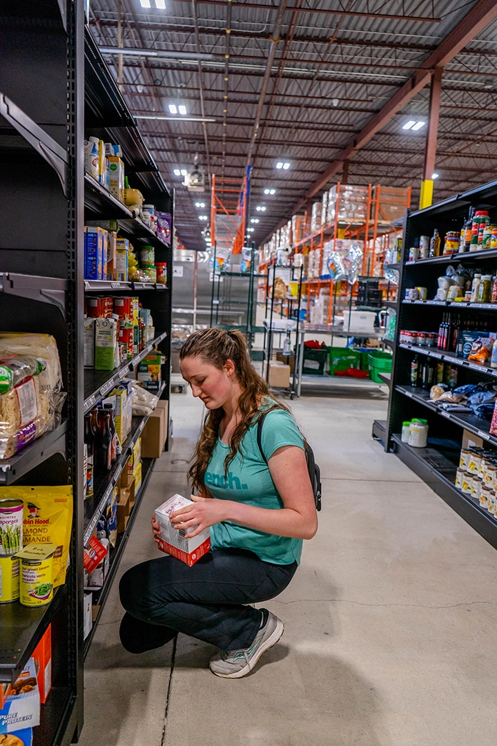 Person shopping for food in warehouse shelves