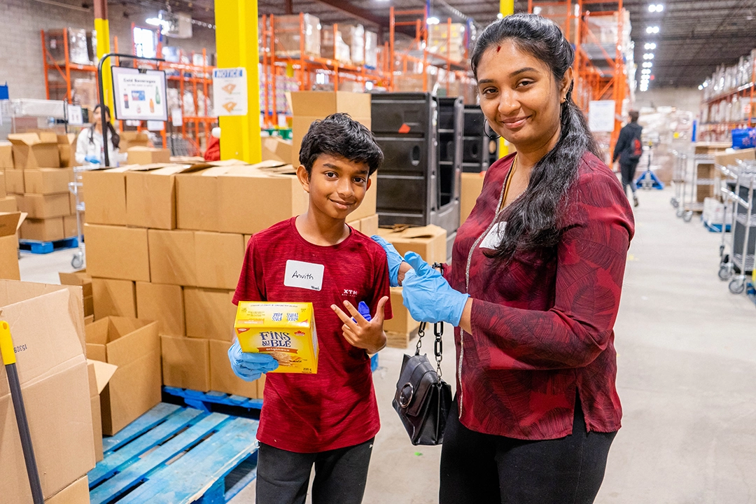 Smiling warehouse volunteers in the Food Banks Mississauga warehouse