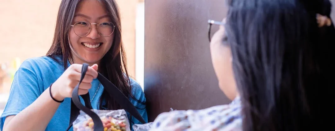 A person handing a bag of food to another person