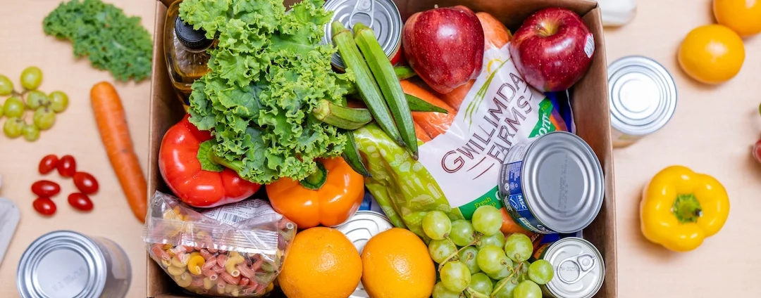 An open box showing different fresh and shelf stable foods